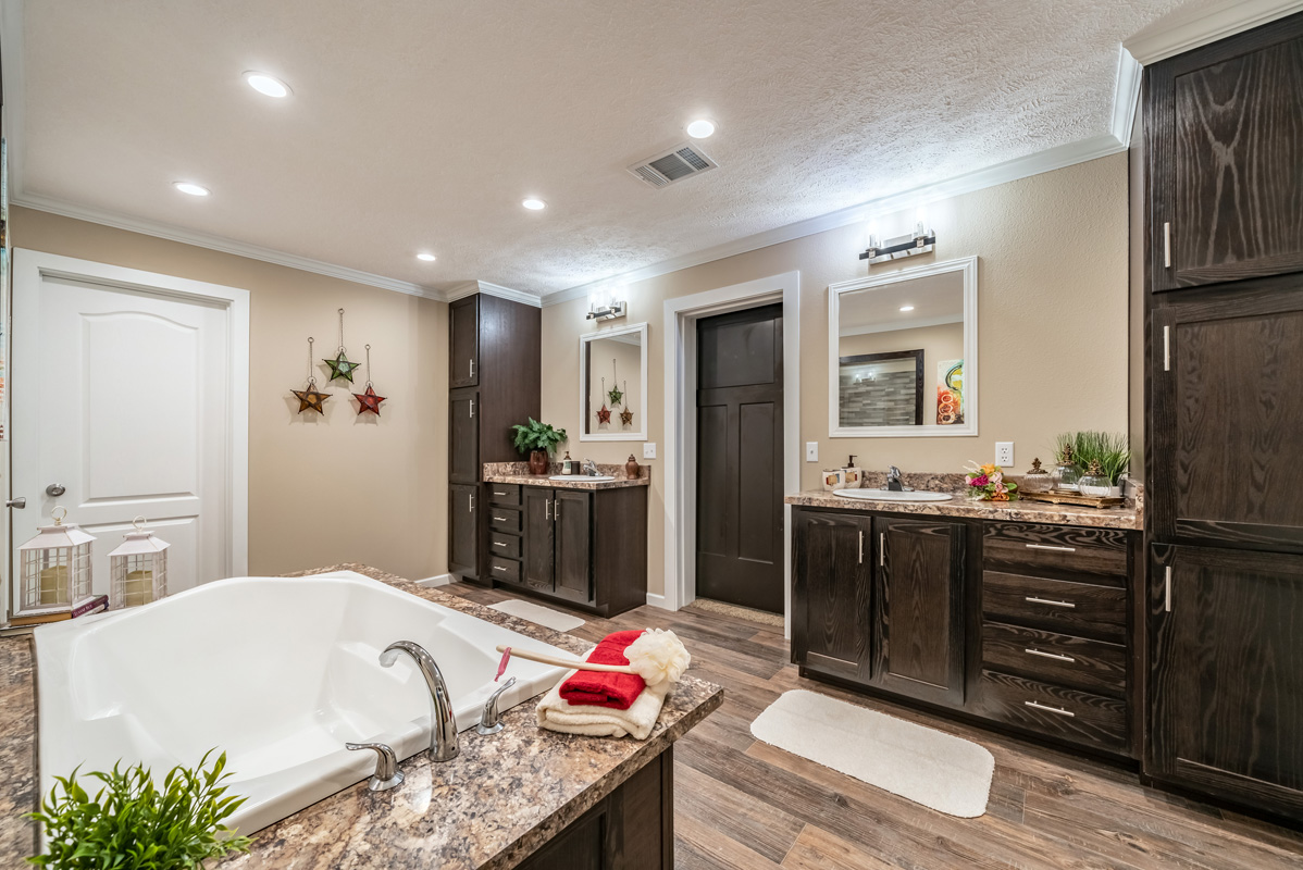 Spacious bathroom with an inviting bathtub, wood cabinetry, and star-shaped wall decor. Warm lighting and rustic elements create a cozy ambiance.